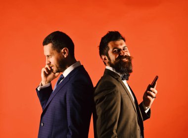 Business call. Machos in classic suits talk on cell phone. clipart