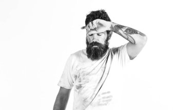 Kirli tozlu gömlekli sakallı adam yorgun görünüyor.