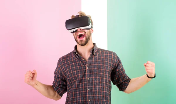 Ganar el juego. Hombre sin afeitar chico con gafas VR involucrados en el espacio cibernético, fondo rosa. Hipster utiliza tecnologías modernas. Espacio cibernético. Guy VR gafas pantalla montada en la cabeza interactuar en el espacio cibernético — Foto de Stock