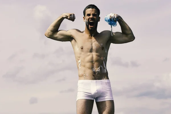 Macho covered with foam holding sponge and shouting like beast