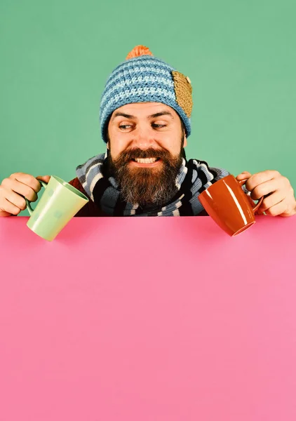 Homme à la barbe tient des tasses marron et vert — Photo
