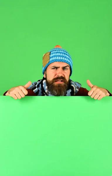 Людина в теплому капелюсі показує великі пальці вгору на зеленому тлі — стокове фото