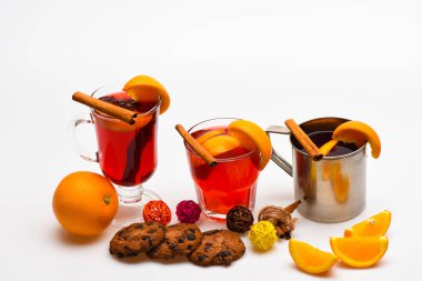 İçmek ya da portakal ve tarçın gözlük ve metal kupa ile içecek sıcak. Kavram hizmet veren Bar. Gözlük ve kupa turuncu ve beyaz arka plan, çerezleri mulled şarap ile yakından