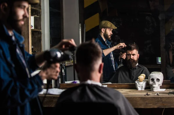 ドライヤー付きの床屋は、ひげを生やした男は、理髪店の背景の髪型で動作します。スタイリング コンセプト。ドライヤー乾燥、クライアントの髪をスタイリングと理髪店します。流行に敏感なひげを生やしたクライアント ヘアスタイルを取得 — ストック写真
