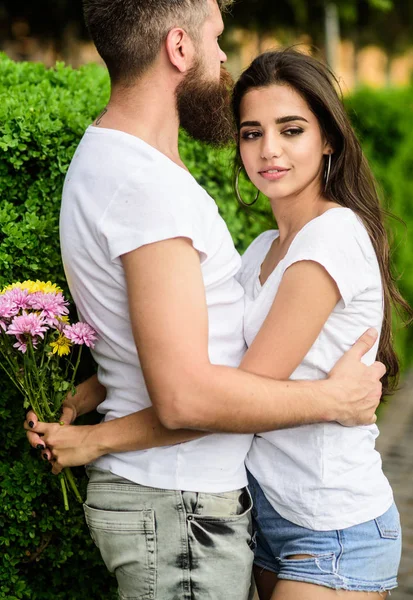 Man fall in love with gorgeous girl. Strong romantic feelings become true love. He will never let her go. Couple in love hugs on date in park green bushes background. Man bearded hipster hugs woman