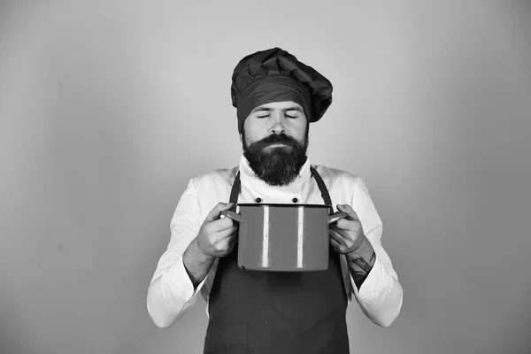Férfi szakállal tartja konyhai eszközök kék háttér. — Stock Fotó