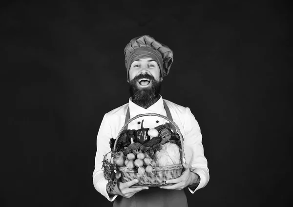 Hombre con barba sostiene verduras sobre fondo negro. —  Fotos de Stock