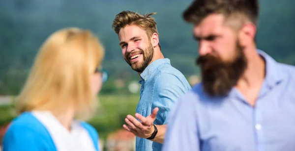 Man with beard jealous aggressive because girlfriend interested in handsome passerby. Husband strictly watching his wife looking at another guy while walk. Passerby smiling to lady. Jealous concept