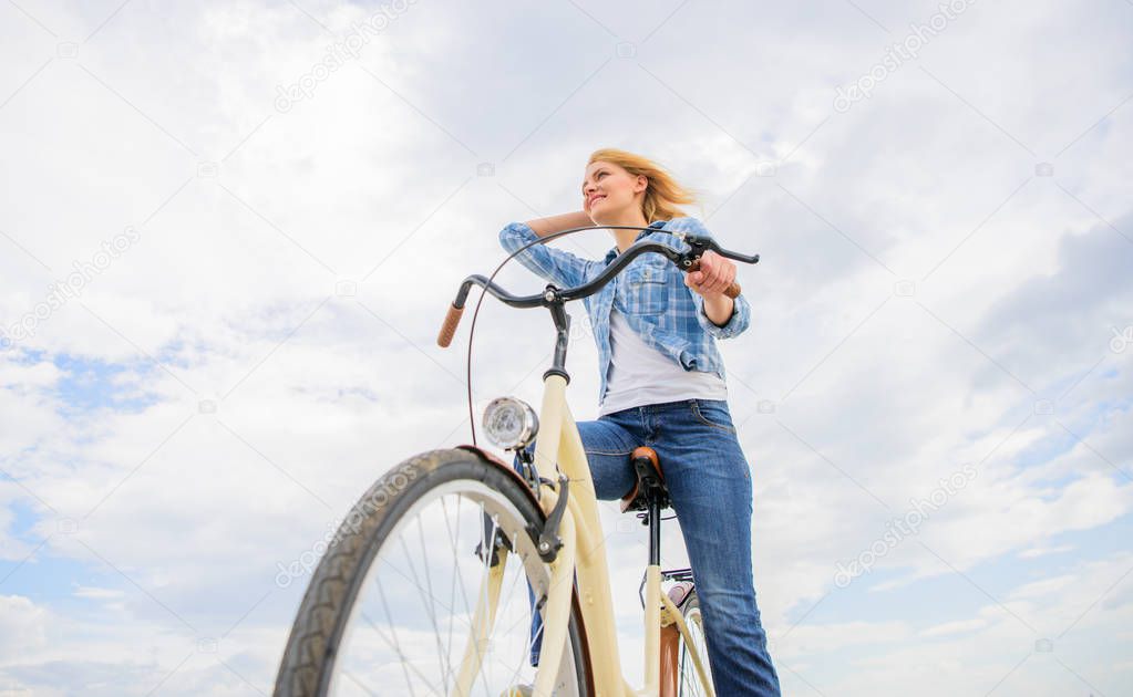 Girl rides bike sky background. Bike rental shops primarily serve people who do not have access to vehicle typically travellers and particularly tourists. Woman rent bike to explore city copy space