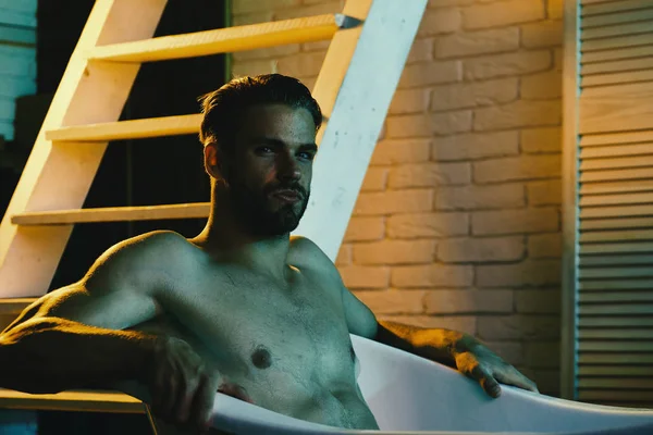 Maço çıplak oturuyor ve küvette dinleniyor, seçici bir odak.