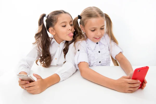 Spaß haben. fröhliche kleine Kinder Mädchen haben Spaß in der Schule mit dem Handy. Studenten des digitalen Zeitalters. Kleine Mädchen haben mobile Abhängigkeit — Stockfoto
