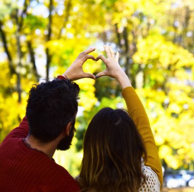 Erkek ve kadın geriye doğru sonbahar ağaçlar arka plan açık