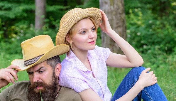 Choisissez les vêtements et l'équipement appropriés pour la randonnée et le pique-nique en forêt. Quelques touristes portant des chapeaux. Couple dans des chapeaux de paille assis prairie détente. Chapeaux pour le tourisme. Raisons pour lesquelles vous devriez certainement porter plus de chapeaux — Photo