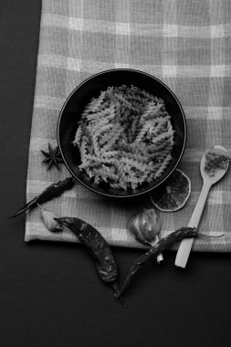 tahta kaşık, chili biber, portakal, sarımsak, Yıldız anason ve tarçın beyaz ve mavi kareli kumaş ya da koyu arka plan, üstten görünüm üzerine kareli kumaş ile seramik tabak lezzetli renkli İtalyan Makarna