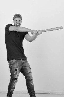 Koyu mavi tişörtlü adam parlak yeşil yarasa tutuyor.