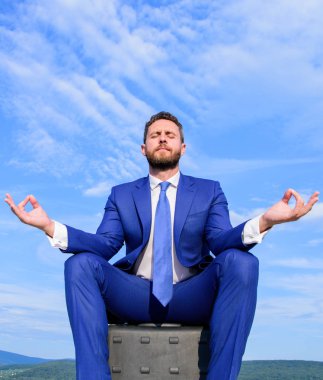 Evrak Çantası'nı ve açık havada meditasyon işadamı resmi elbise sit. Adam zihnini açık tutmaya çalış. Gevşeme tekniği. Ruhu içinde sakin tutmak. Girişimci bulmak dakika dinlenip, meditasyon