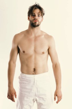 Güçlü kasları olan bir sporcu. Yüzü açık ve ciddi bir adam