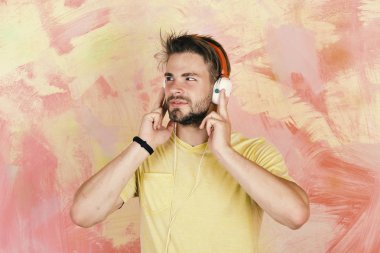 Amerikan yakışıklı adam kulaklıklarla sakallı. Müzikal yaşam tarzı. Smartphone ile mavi gözlü şık hippi. Avrupa adam var eğlenceli zaman. Neşeli genç dj dinleme şarkı yolu ile kulaklık