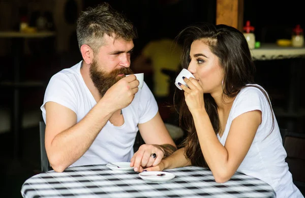 Par i kärlek dricka svart espressokaffe i café. Mannen med skägg och attraktiva glada leende flicka Håll händerna dricka kaffe. Njut av ögonblicket med kopp kaffe drink. Par gärna tillbringa tid i café — Stockfoto