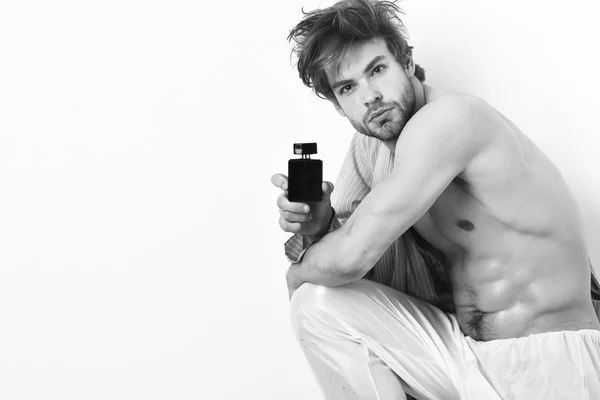 Hombre barbudo con cara seria y frasco de perfume . — Foto de Stock