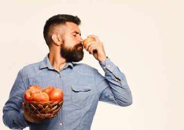 Sakallı adam elma meyveli hasır kaseyi tutuyor.