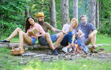 Gençlik hiking tatil. Yürüyüşçü Orman Doğa arka planda boş zaman harcamak. Yürüyüşçüler yemek ve dinlenmek için hızlı piknik düzenledi. Piknik fikirler zammı. Kamp ateşi gıda kavurma bekleme sırasında rahatlatıcı yakınındaki yürüyüşçü oturmak