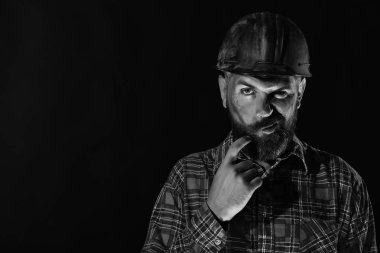 Kalın sakallı işçi ya da inşaatçı. Acımasız görüntüsü olan adam.