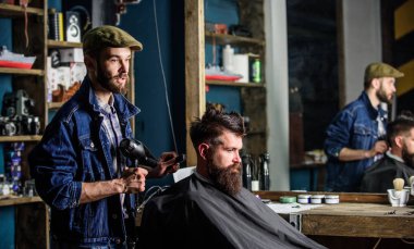 Sakallı adam Kuaför Berber Dükkanı, sandalyede otururken kurutucu saçlı, bakımlı. Hipster kavramı. Hippi saç modeli almak istemci sakallı. İstemci saç kurutma saç kurutma makinesi ile berber