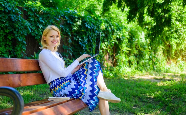 Tempo livre navegando na internet no parque. Menina sentar banco com caderno. Rede de surf na natureza. Mulher com laptop funciona ao ar livre, fundo natureza verde. Lady freelancer internet surf ou trabalhando no parque — Fotografia de Stock