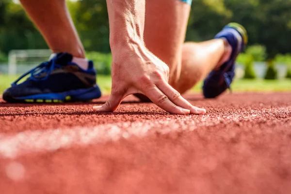 Gemeinsame Betreuung der Läufer. Hand des Sportlers auf Laufstrecke niedrige Startposition. Läufer bereit, um aus nächster Nähe zu gehen. ultimative Heilmittel. Flexibilität ist Fähigkeit, Gelenke zu dehnen, um die Reichweite der Bewegung zu begrenzen — Stockfoto