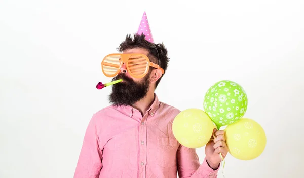 Homem com barba e bigode no rosto calmo contém balões de ar, fundo branco. O tipo de chapéu de festa com chifre de festa celebra. Hipster em óculos de sol gigantes comemorando aniversário. Conceito de partido — Fotografia de Stock