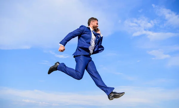 Nooit stoppen. Zakenman formele pak springen terwijl oproep smartphone hemelachtergrond. Zakenman oplossen van bedrijfsproblemen op telefoon. Ondernemer in beweging succes expressie. Ga naar uw doel — Stockfoto