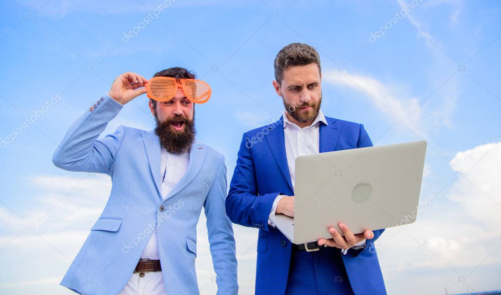 Businessman with laptop serious while business partner ridiculous glasses looks funny. Unprofessional behaviour. How stop play entrepreneurship and get serious business. Event management industry