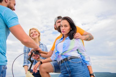 Grup arkadaşları Bisiklet ile takılmak. Nasıl bisiklet toplum değişti. Çift neşeli Bisiklet ile yürüyüş sırasında arkadaşlar. Şirket şık gençler boş zaman açık havada gökyüzü arka plan harcamak