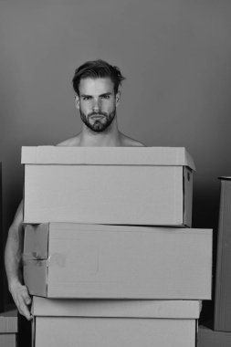 Teslimat ve kavram olarak hareket. Güçlü kolların kalın karton boksör yığını tutan adamla