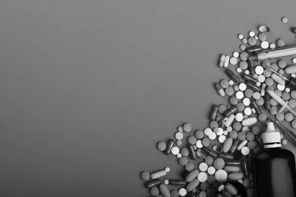 Cadre composé de pilules rondes et de capsules placées dans un coin. Ensemble de pilules colorées dispersées sur fond rose, espace de copie — Photo