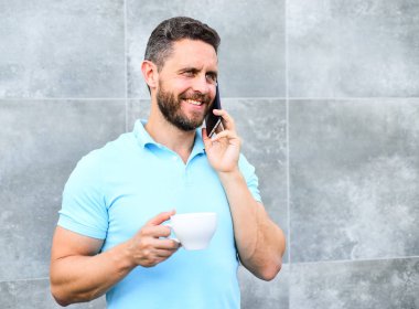 Üstünde belgili tanımlık gitmek kahve içmek her SIP biraz ara günün ve öz bakım küçük anı olsa bile. Nedenleri girişimciler kahve içmek. Adam içki kapuçino konuşmak telefon gri duvar arka plan
