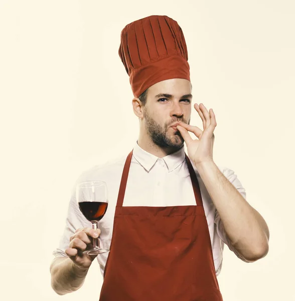 Laga mat med nöjd ansikte innehar glas vin. Kock i Bourgogne enhetliga visar perfekt smak tecken. — Stockfoto