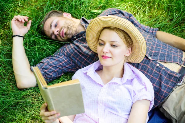 Coppia innamorata trascorrere il tempo libero libro di lettura nel parco. Un paio di anime gemelle ad un appuntamento romantico. Famiglia godere il tempo libero con poesia o letteratura libro erba sfondo. Uomo e ragazza giacevano sull'erba lettura libro — Foto Stock