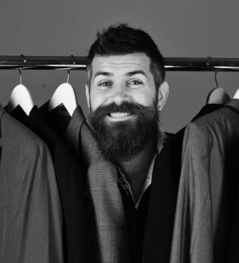 Tezgahtar ya da satıcı elbise askılarında takım elbiselilerin arasına saklanır.