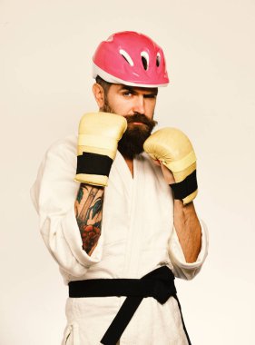Karate altın boks eldivenleri uygulamaları saldırı veya savunma kendine güvenen yüzüne adamla. Kimono ve pembe kask beyaz sakallı