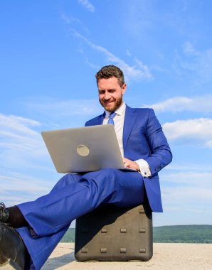 İyi iş dizüstü bilgisayarlar. Dizüstü vazgeçilmez öznitelik modern iş adamı. İşadamı defter sit evrak çantası mavi gökyüzü arka plan ile. Modern teknolojiler taşınabilir aygıt fırsat iş dünya çapında