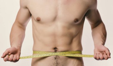 Güçlü kasları ile sporcu bel veya sixpacks ölçer. Beyaz arka plan üzerinde çıplak göğüs adamla. Adam bandı ile