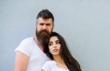 Çift şık genç modern insanlar. Kentsel sevgi dolu çift. Çift beyaz gömlek birbirlerine dikkat ediniz. Hipster sakallı ve şık bir kız açık havada takılmak. Aşık çift birlikte gri duvar arka plan asmak
