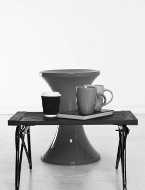 Kağıt bardak ve beyaz arka plan, kopya alanı üzerine bir kitap kırmızı sandalye ve kırmızı yeşil siyah ahşap tepsi.