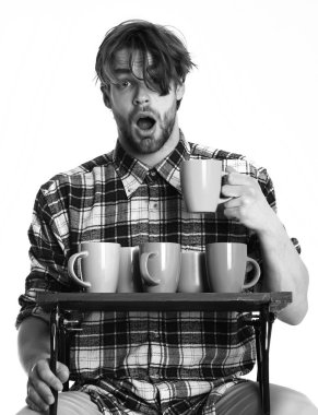 renkli bardak beyaz arka plan üzerinde izole tepsi tutarak yüz sürpriz. yakışıklı adam beyaz arka plan üzerinde izole bardak