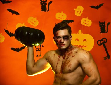 Adam yüzüme ve göğüs üzerinde kan olan kabak tutar.