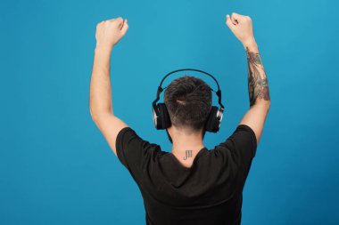 Adam ellerini tutar, mavi arka plan üzerinde dans döndü. Sakin ol ve müzik konsepti. Şarkıcı sakallı müzik hoşlanır.