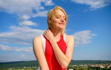 Kolay gelsin. Kız sıcak güneş ışığı ile memnun rahat mavi gökyüzü arka plan görünüyor. Kadın sarışın rahatlatıcı açık havada. Refah ve uyum hakkında dakika kendine iyi bak. Uyum ve barış hissediyorum