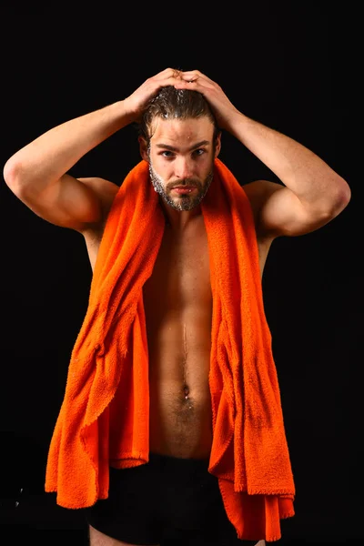 Macho attraktiva naken kille svart bakgrund. Man med orange handduk torka håret. Tvätta noga av skum med vatten. Applicera balsam efter dusch. Man bearded rufsig hår täckta med skum såpvatten — Stockfoto
